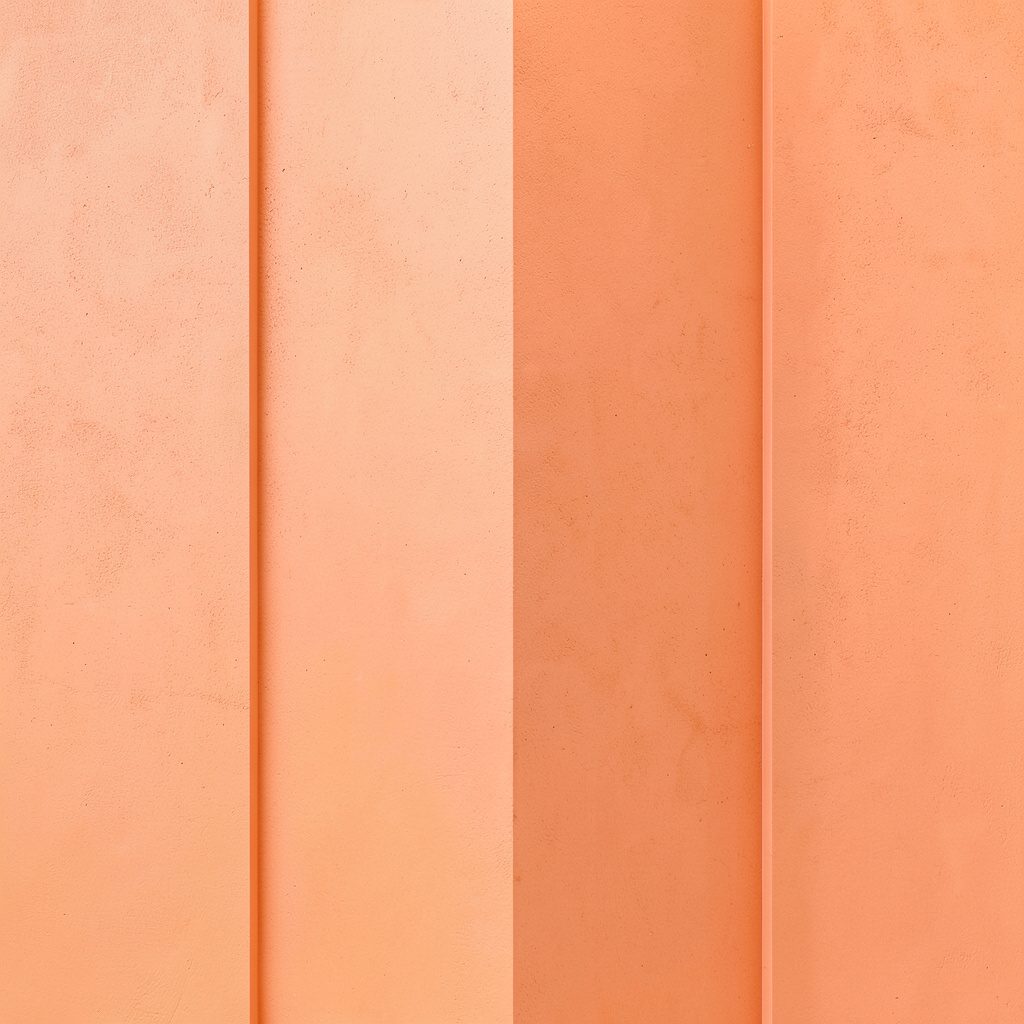 Warm peach-toned abstract detail of brushed concrete surface with subtle geometric texture